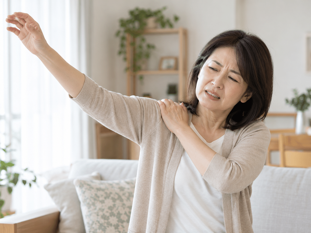 肩を押さえて腕を上げようとしている女性